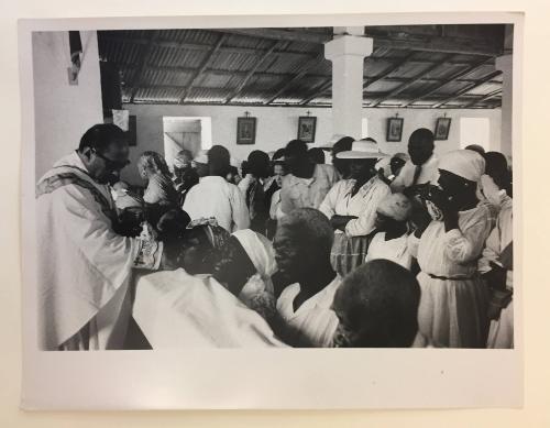 Priest distributing Communion in Haitian Catholic church