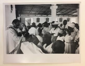 Priest distributing Communion in Haitian Catholic church