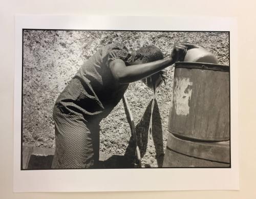 Woman washing with pot of water, Haiti