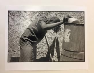 Woman washing with pot of water, Haiti