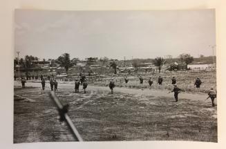 Soldiers walking in a field with camps, From the Life magazine story “Santo Domingo Civil War”
