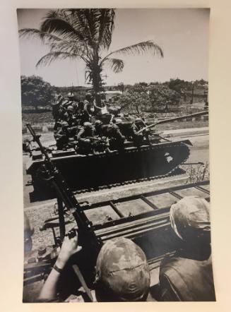 Soldiers sitting on tanks