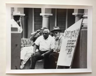 Men on street bench, Cuba