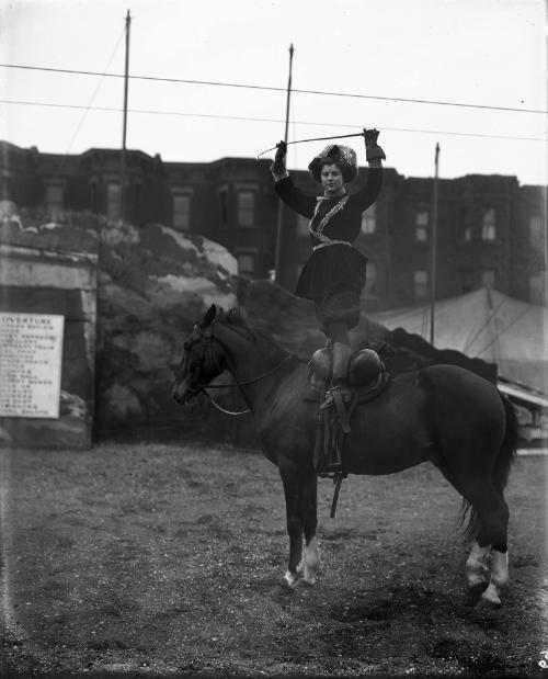Female Equestrian Dressed as Cossack Standing atop Horse