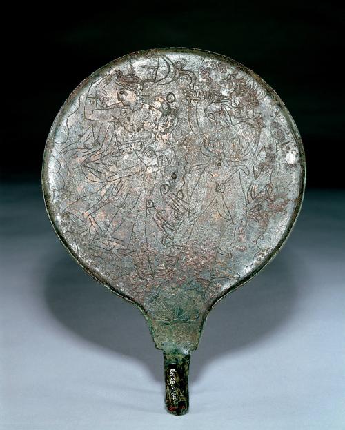 Mirror engraved on the backside with a Dionysiac scene of a dancing woman (maenad) wearing a belted tunic, cloak, slippers, earrings, choker, strands of body jewelry, and wrist bracelets, and a satyr playing a double pipe and wearing boots and an animal skin