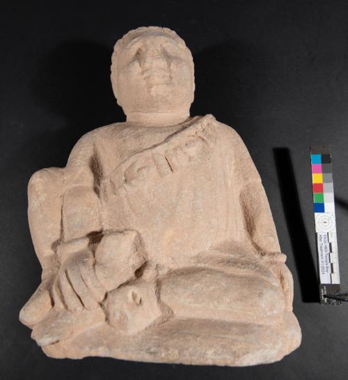 Temple boy holding a bird and wearing a short-sleeved tunic, string of amulets with seal-rings, and wrist bracelets