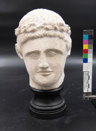 Male statue head wearing a wreath of leaves