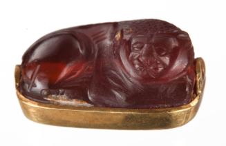 Seal-amulet in the shape of a lion in repose, underside with a dolphin-headed man in waves