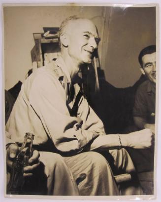 Ernie Taylor Pyle Sits and Smiles as Group of Men Enjoy Coca Cola