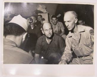 Ernie Taylor Pyle Sits with a Serious Expression Next to A Heavier Man