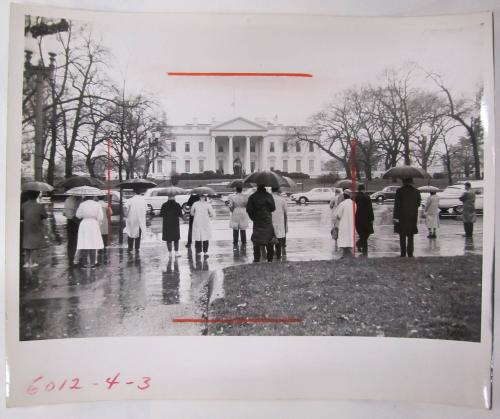 The White Houe with People Standing Across the Street Under Umbrellas Facing it