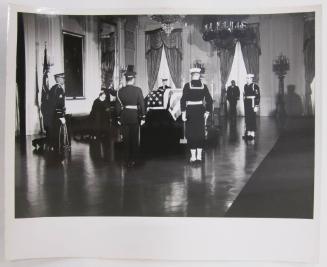 The Casket of John F. Kennedy, with Honor Guard and Praying Priest in the East Room of the White House