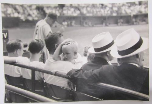 Child Looks Over his Father's Shoulder at a Baseball Game