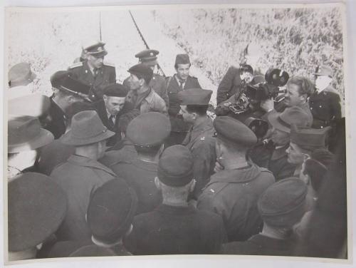 Paparazzi, Officers, and Crowd Gather Around for an Autograph