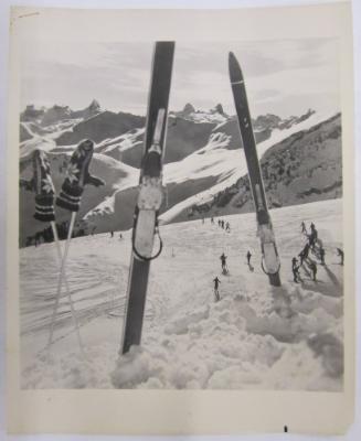 Snow Covered Mountain with Skis and Ski Poles Lodged in Snow