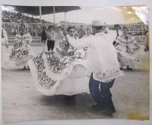 Men and Women Dance in Front of an Arena of People