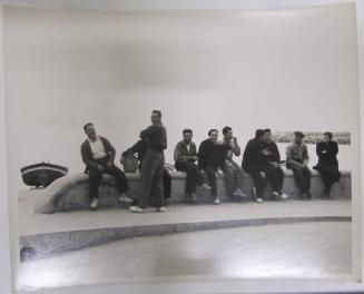Group Sits and Converses on Sea Wall