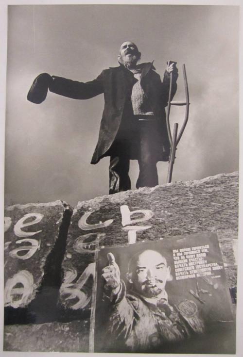 Man with Crutch Standing on Former Base of a Statue of Lenin