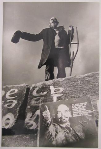 Man with Crutch Standing on Former Base of a Statue of Lenin