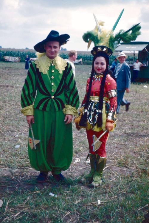 2 performers in green and red costumes in BY