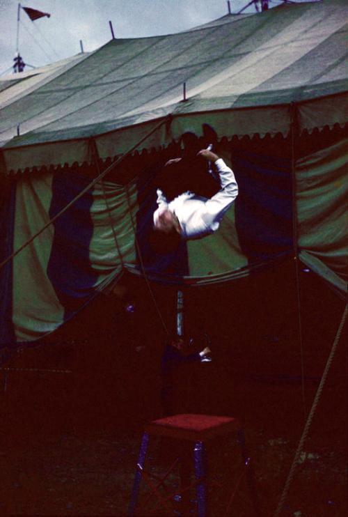 Peformer flipping in front of tent