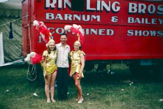 2 ladies in gold costumes and one plain clothed man