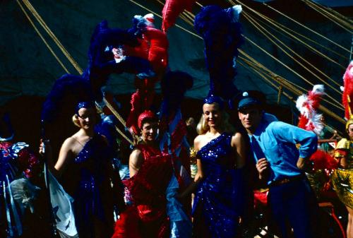 2 ladies in blue costumes, 1 lady in red, and 1 man in blue uniform