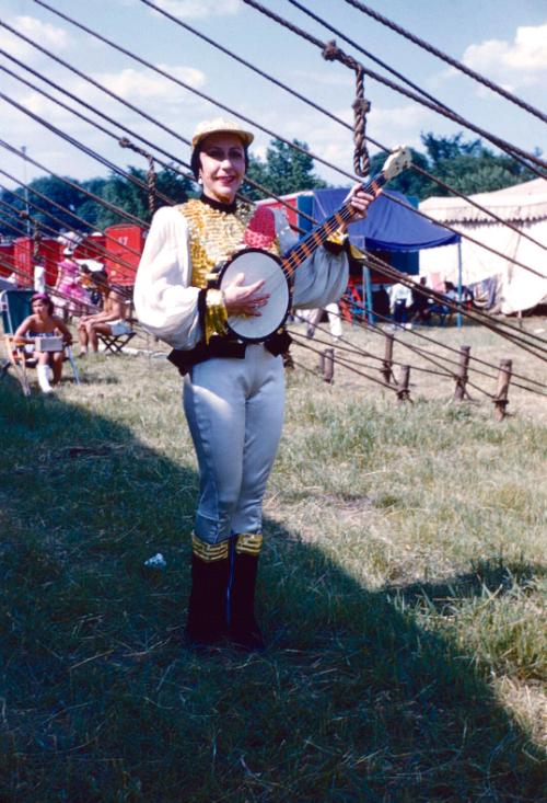 Dolly Copeland in white, black, and gold garb playing banjo